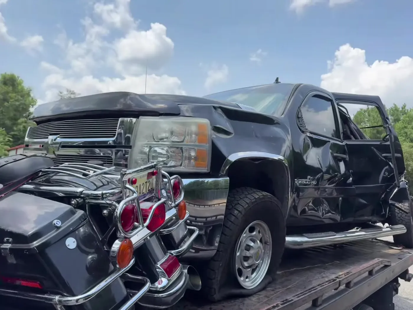 A touring motorcycle loaded alongside a recovered pickup.