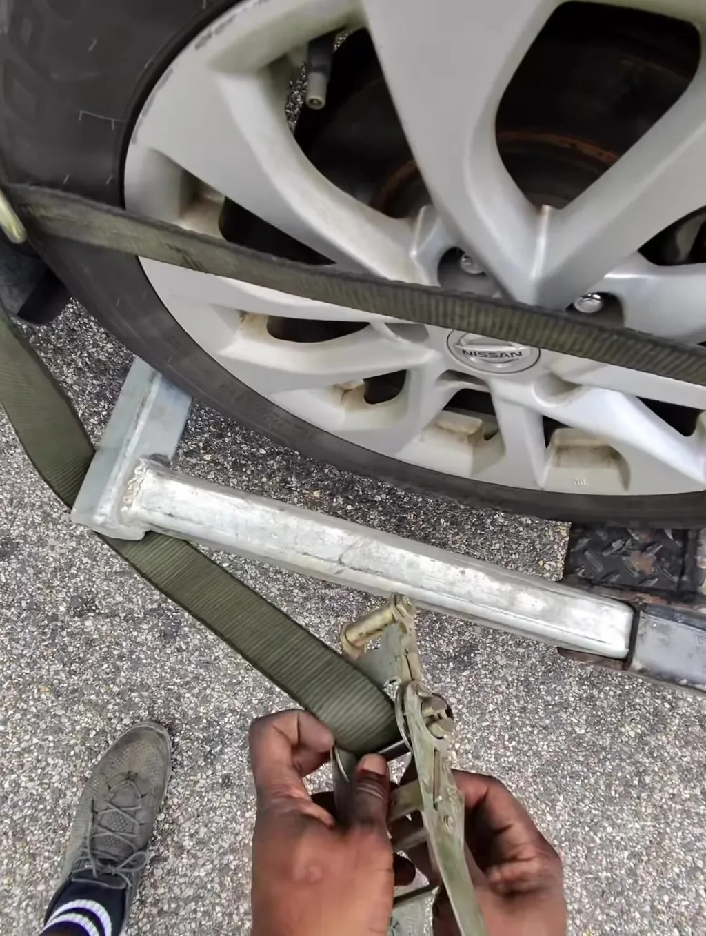 Ratchet tensioned at the corner. Every vehicle gets strapped at four points before it moves.